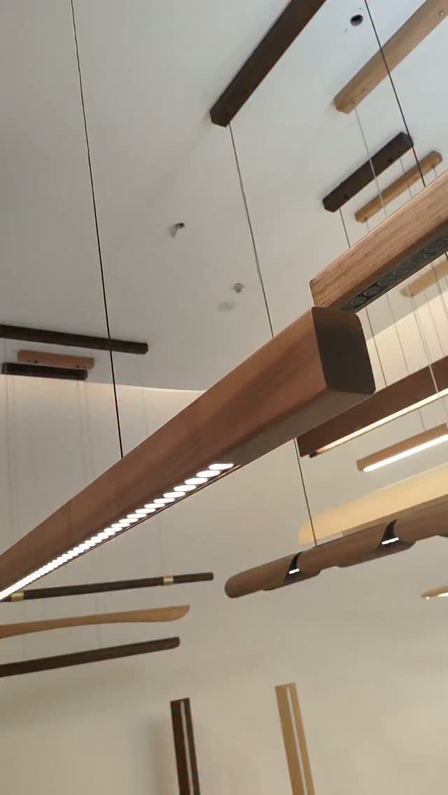Wood Lamp Design: 14 Table, Floor and Pendant Ideas 10 Linear wooden pendant lights hanging from a white ceiling with warm LED illumination.