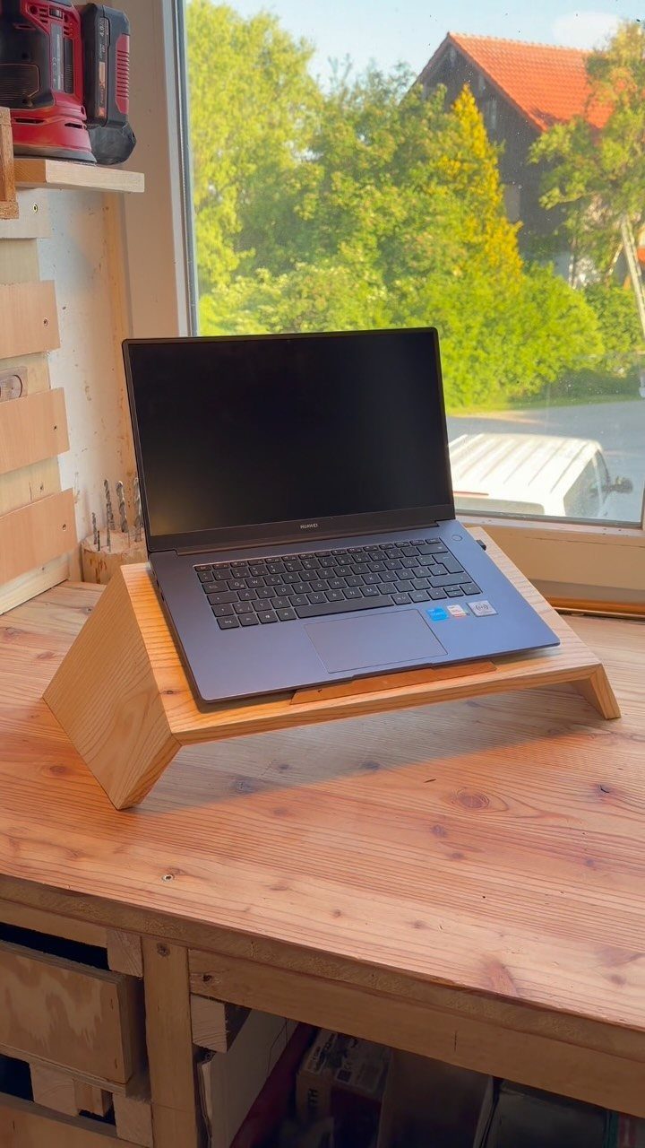 17 Wood Pallet Projects for Furniture, Decor, and Garden 12 Black laptop on a light wooden stand atop a rustic wooden workbench.
