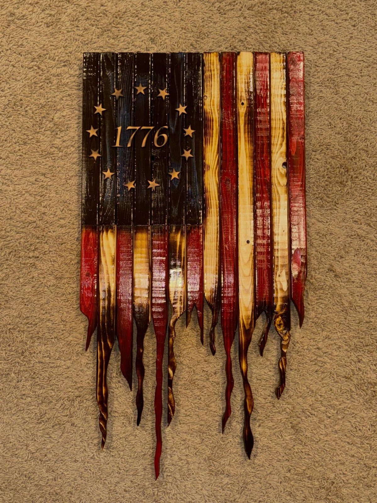 17 Wood Pallet Projects for Furniture, Decor, and Garden 16 Wooden American flag with 1776 and flame-shaped bottom edges on tan carpet