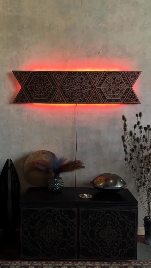Wood Piece Art Ideas: 25 Designs for Walls and Shelves 2 Geometric carved wooden wall panel with red backlighting above a black cabinet