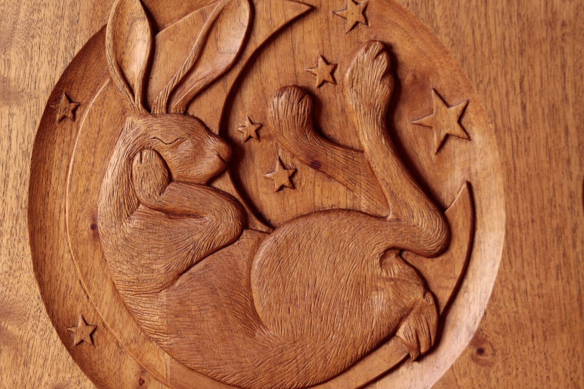 Wood Piece Art Ideas: 25 Designs for Walls and Shelves 17 Carved wooden plaque of a sleeping rabbit with a crescent moon and stars.