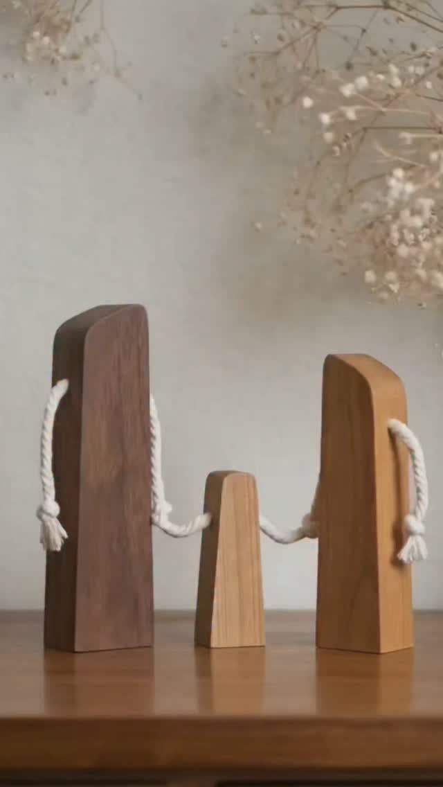 Wood Piece Art Ideas: 25 Designs for Walls and Shelves 15 Three minimalist wooden blocks connected by white rope on a wooden table.