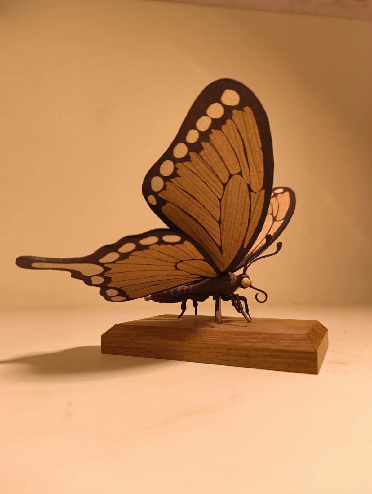 Wood Piece Art Ideas: 25 Designs for Walls and Shelves 22 Wooden butterfly sculpture with orange and black wings on a wooden base.