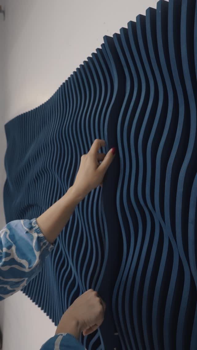 Wood Piece Art Ideas: 25 Designs for Walls and Shelves 8 Blue wavy wooden wall installation with a hand touching the undulating slats.