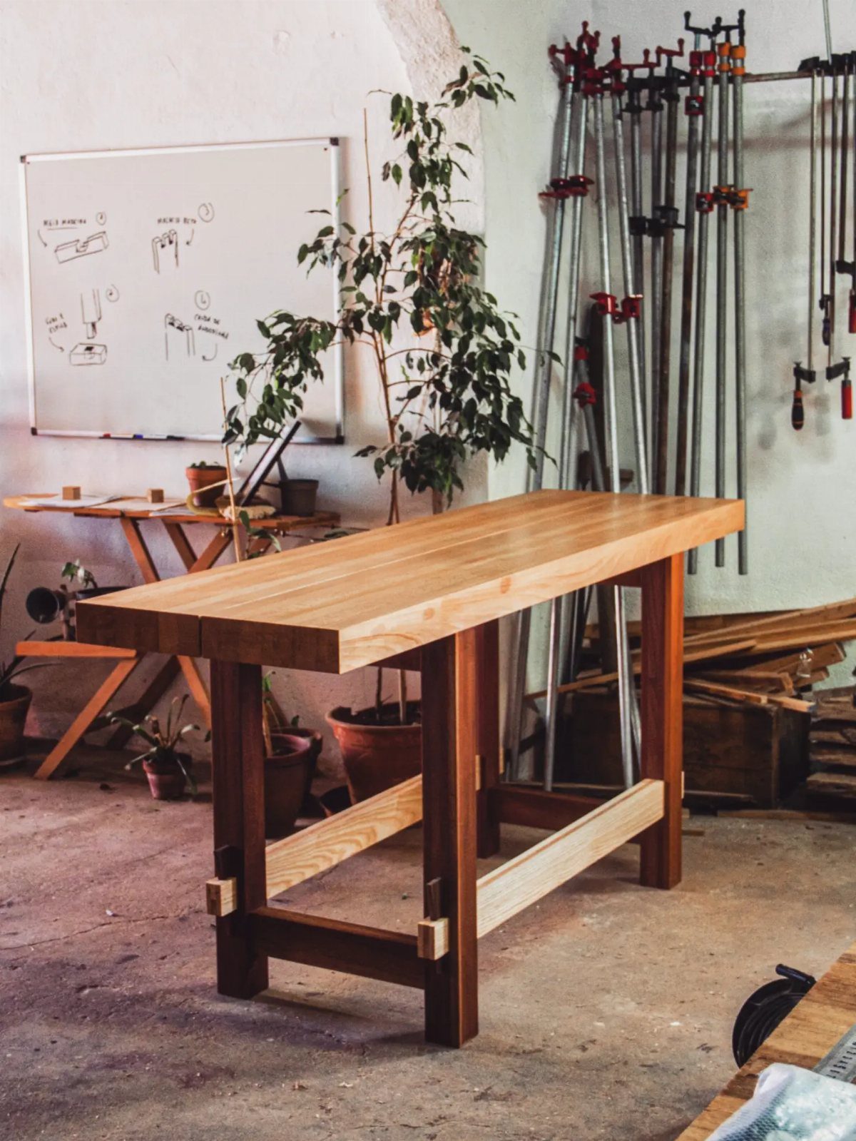 18 Wood Projects with Plans for Every Skill Level 12 Long wooden entry table with a thick top and dark legs in a workshop