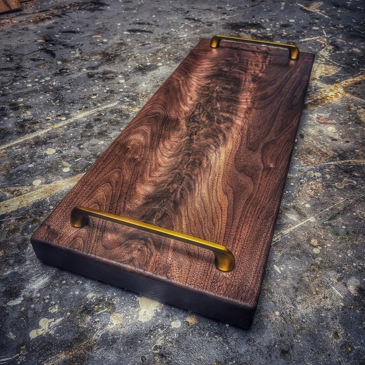 18 Wood Projects with Plans for Every Skill Level 15 Dark wood serving tray with gold handles on a grey textured surface