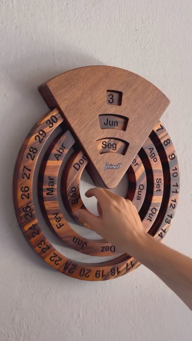 18 Wood Projects with Plans for Every Skill Level 16 Wooden perpetual calendar on a white wall being adjusted by a person's hand