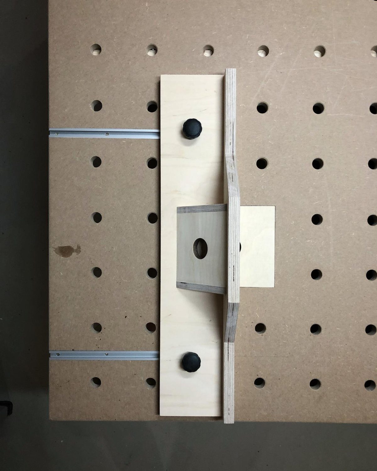 Wood Router Table Ideas: 6 Setups for Your Workshop 5 Wood router table surface with a grid of holes and a wooden fence.