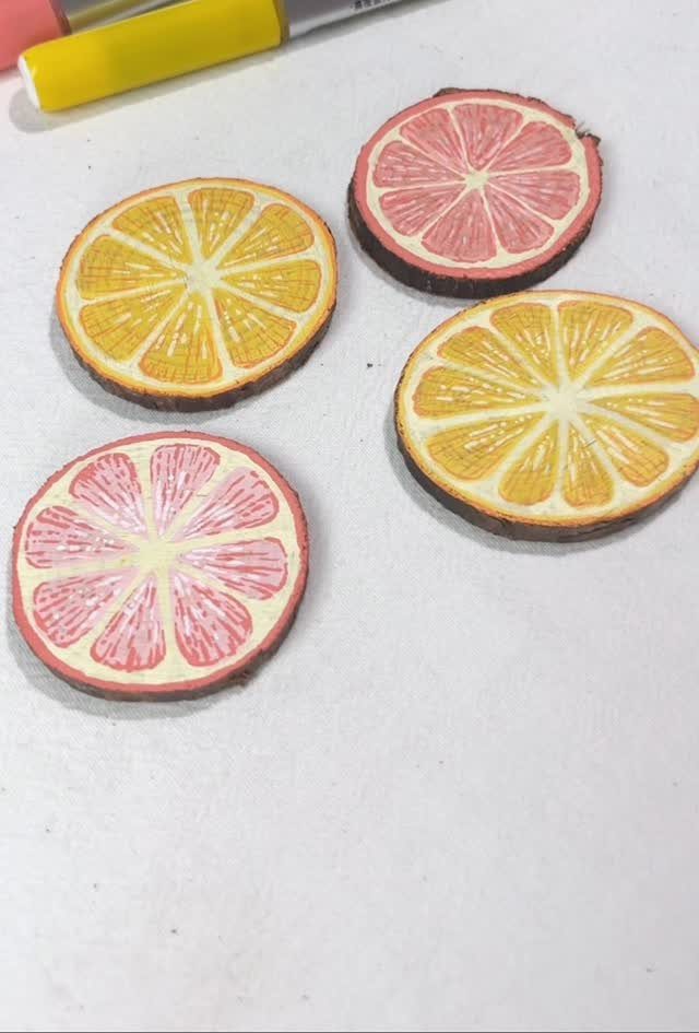 Four painted wood slice coasters resembling lemon and grapefruit slices on white background.