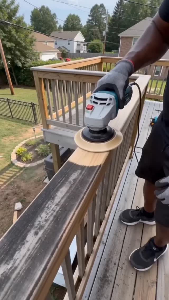 Can You Apply Wood Stain Over Stain? 3 Ideas That Help 3 Person using a power sander to remove old stain from a wooden deck railing.