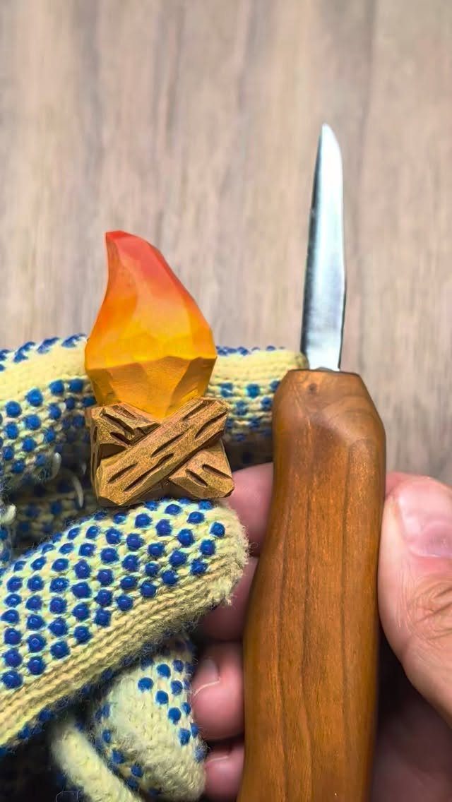Whittled wooden campfire with a colorful flame and a wood carving knife.
