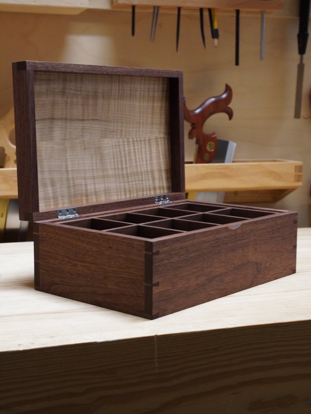 7 Wooden Box Designs for Jewelry, Tissue and Storage 1 Dark brown wooden box with internal dividers and finger joints on a workbench.