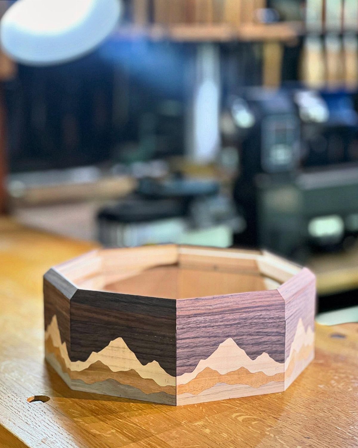 7 Wooden Box Designs for Jewelry, Tissue and Storage 2 Hexagonal wooden box with a mountain landscape design on a workshop table.