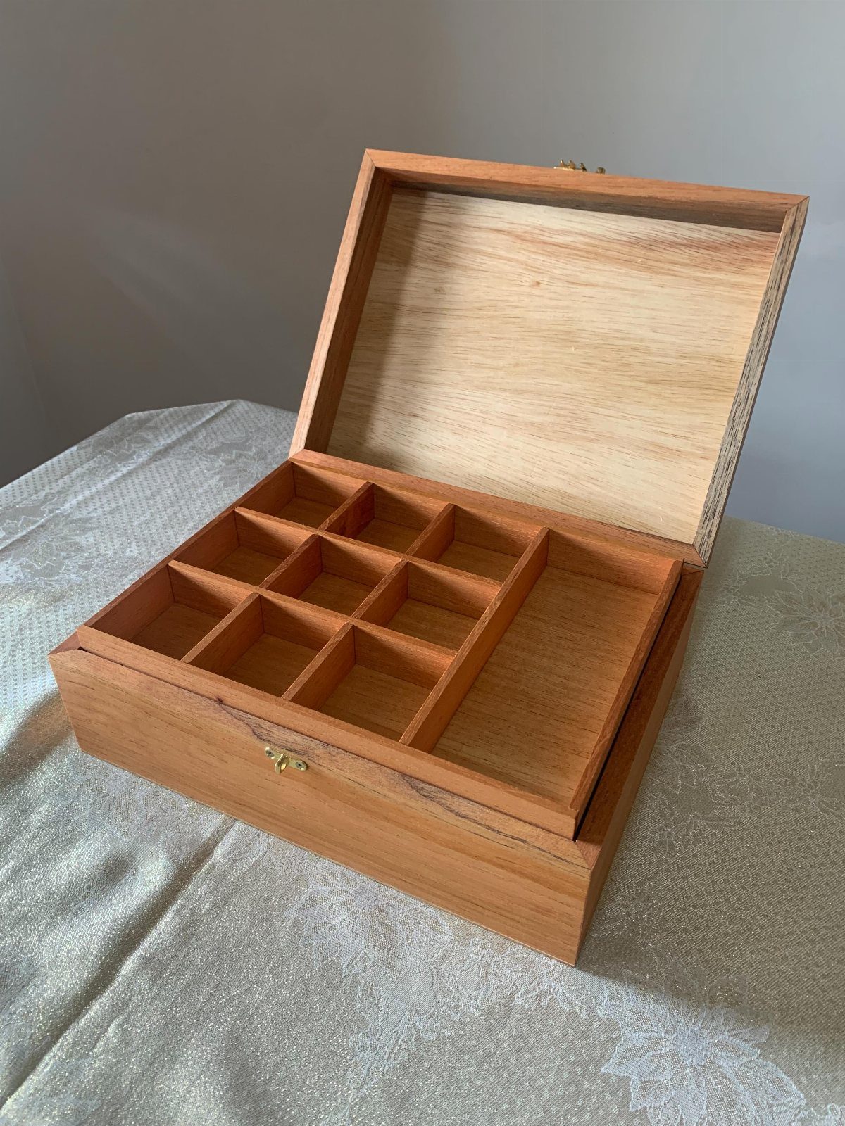 7 Wooden Box Designs for Jewelry, Tissue and Storage 5 Open light-brown wooden box with divided compartments on a silver fabric surface