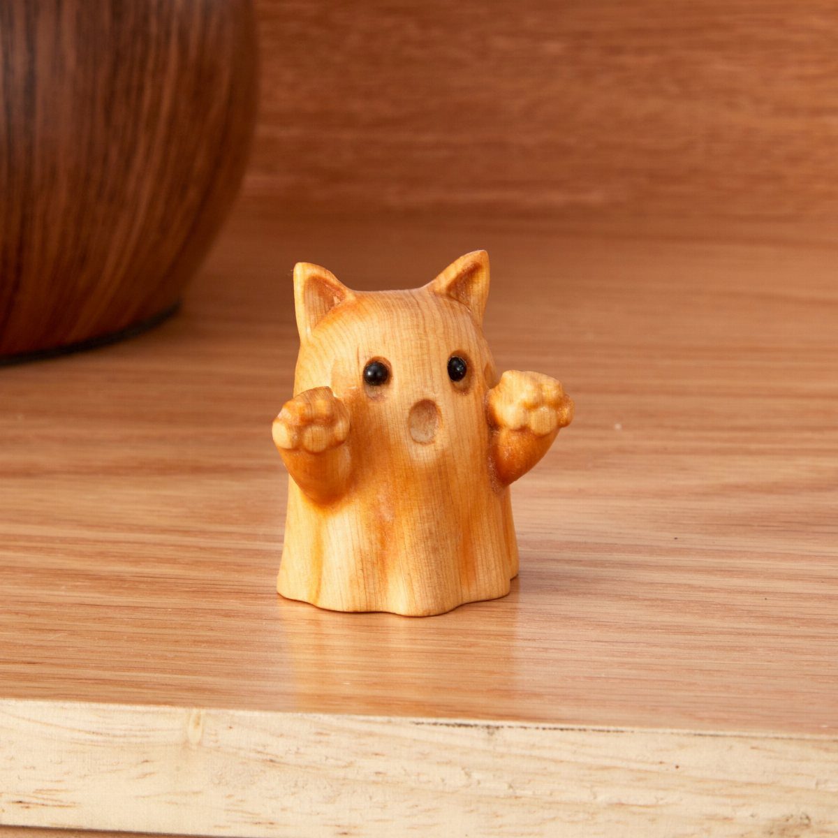 Wooden Cat Face Ideas: 5 Cutouts, Carvings and Wall Art 2 Small carved wooden cat sculpture with a surprised expression on a wooden surface.