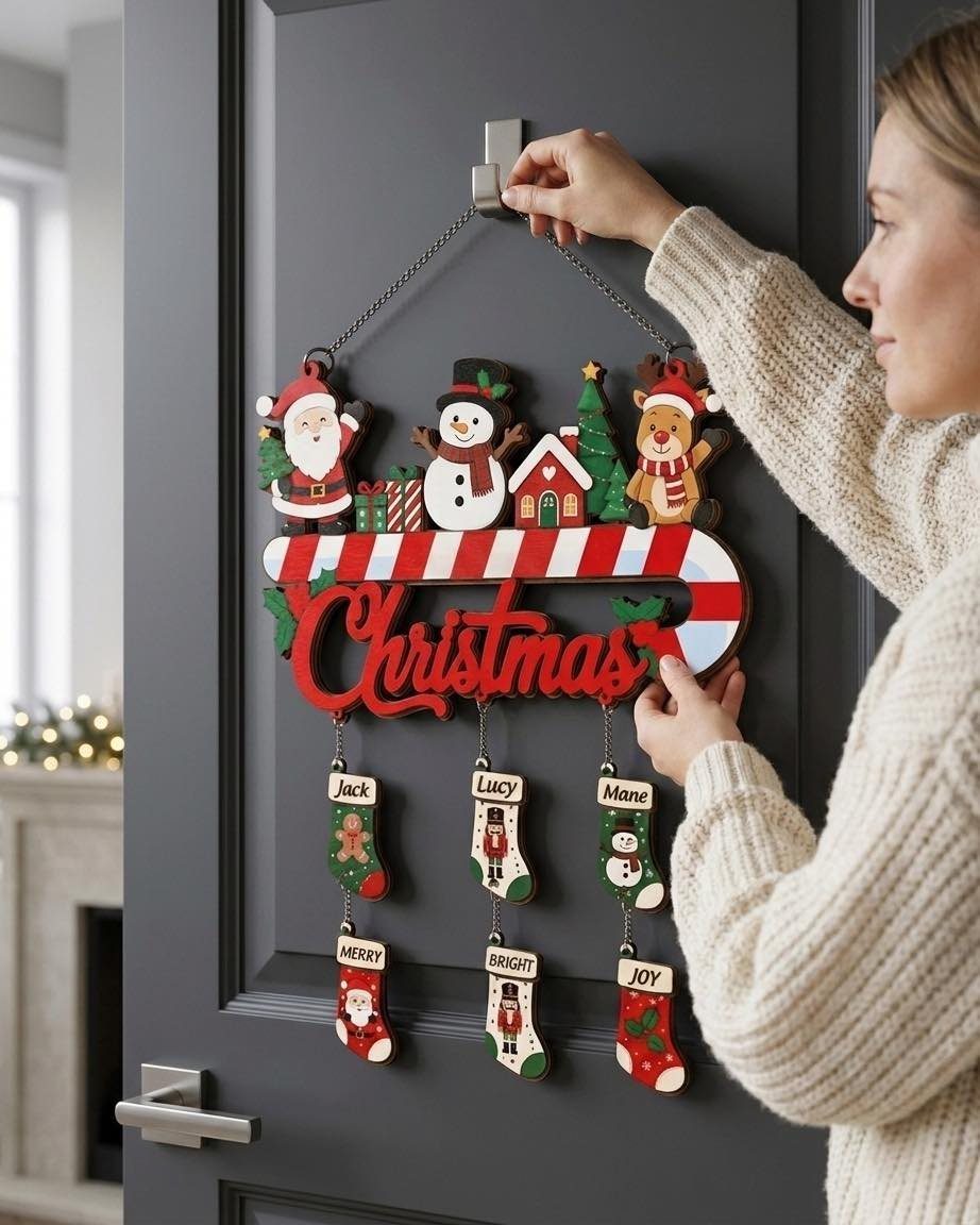 Wooden Christmas wall decoration with small stockings hanging from a candy cane banner.