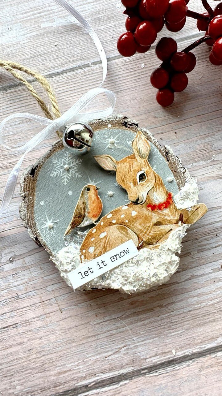 Wooden slice ornament with a painted deer, bird, and 'let it snow' tag.