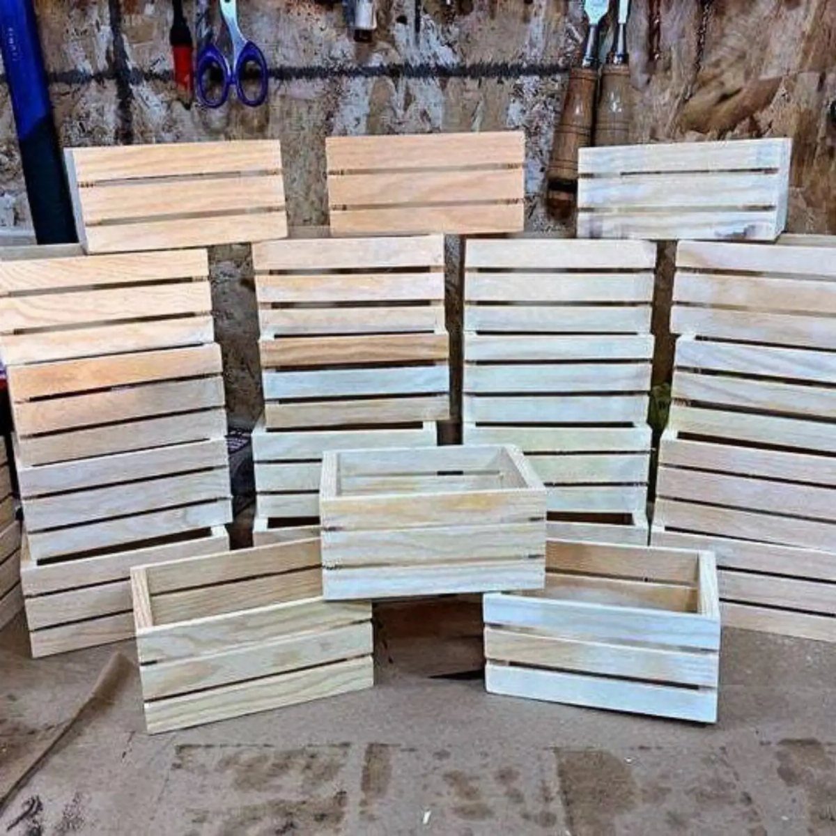 Wooden storage bins with slatted sides stacked in a rustic workshop setting.