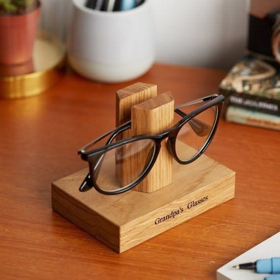 Wooden Glasses Holder: 10 Ideas for Every Desk 3 Black glasses on a light wooden stand engraved with Grandpa's Glasses on a table.