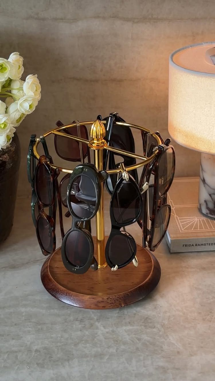 Wooden Glasses Holder: 10 Ideas for Every Desk 4 Rotating sunglasses organizer with gold metal frame and wooden base holding dark glasses.