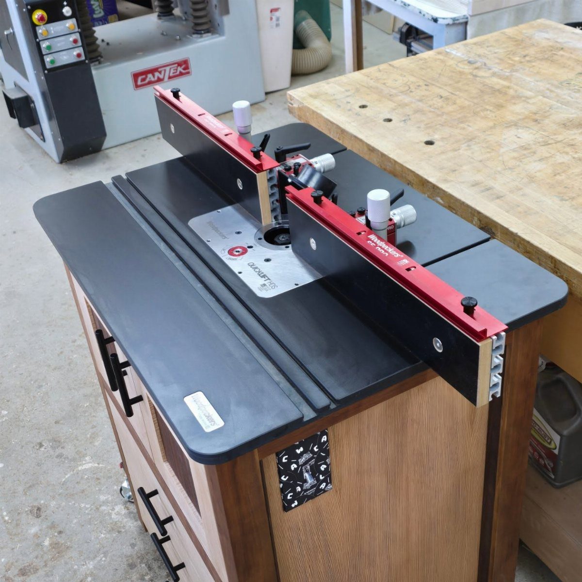 Woodpeckers Router Table Setups: 5 Ideas for Your Shop 2 Woodpeckers router table with red fence on a wooden cabinet in a workshop.