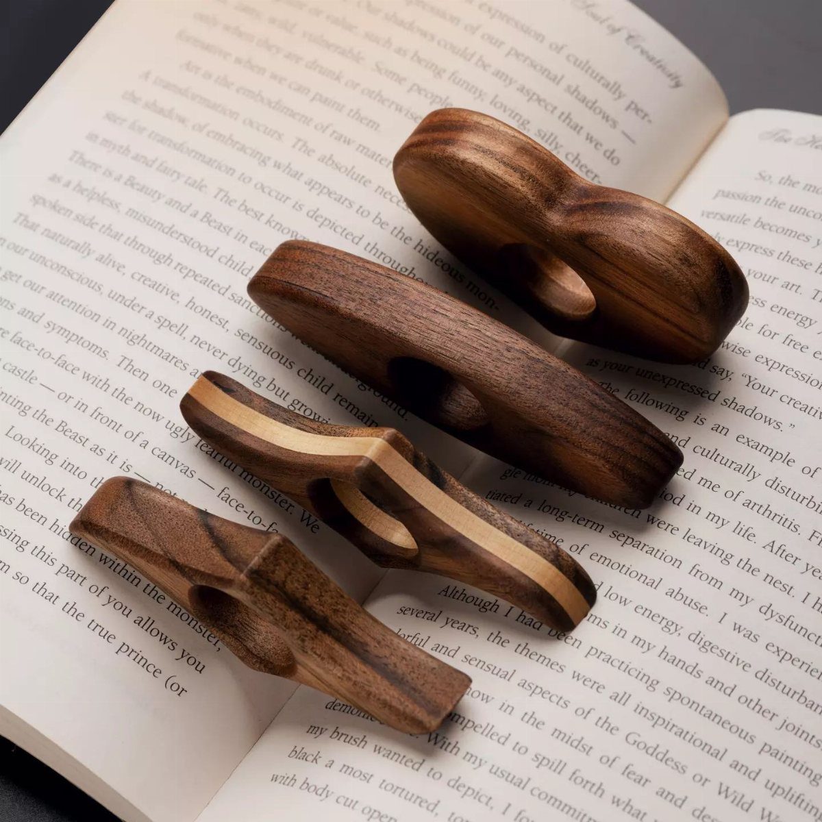 Woodworking Book Holder Ideas: 4 Designs to Build 2 Wooden thumb book page holders resting on the open pages of a book