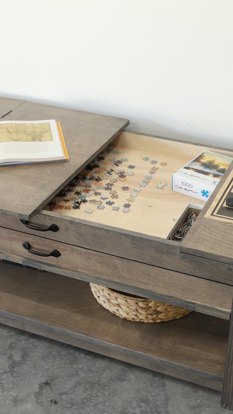 9 Woodworking Coffee Table Ideas for Every Skill Level 9 Grey-brown wooden coffee table with a lift-up top revealing a jigsaw puzzle.
