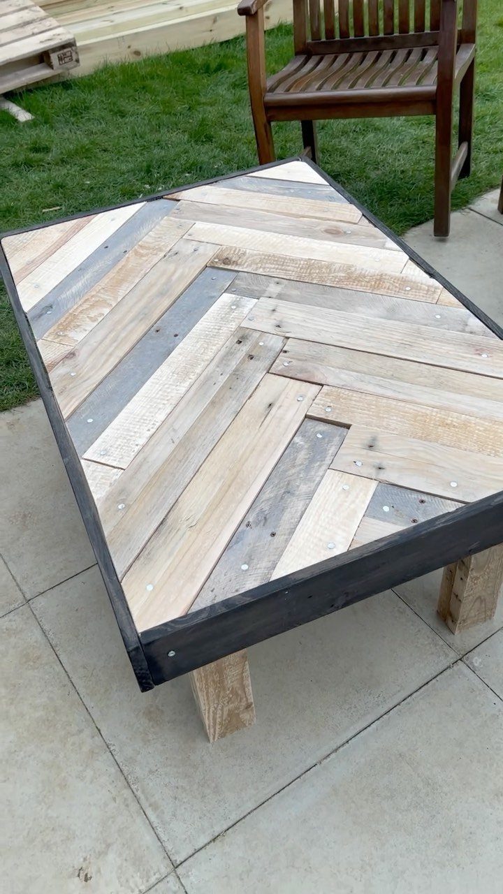 9 Woodworking Coffee Table Ideas for Every Skill Level 3 Reclaimed wood coffee table with herringbone top and black metal frame on a patio.