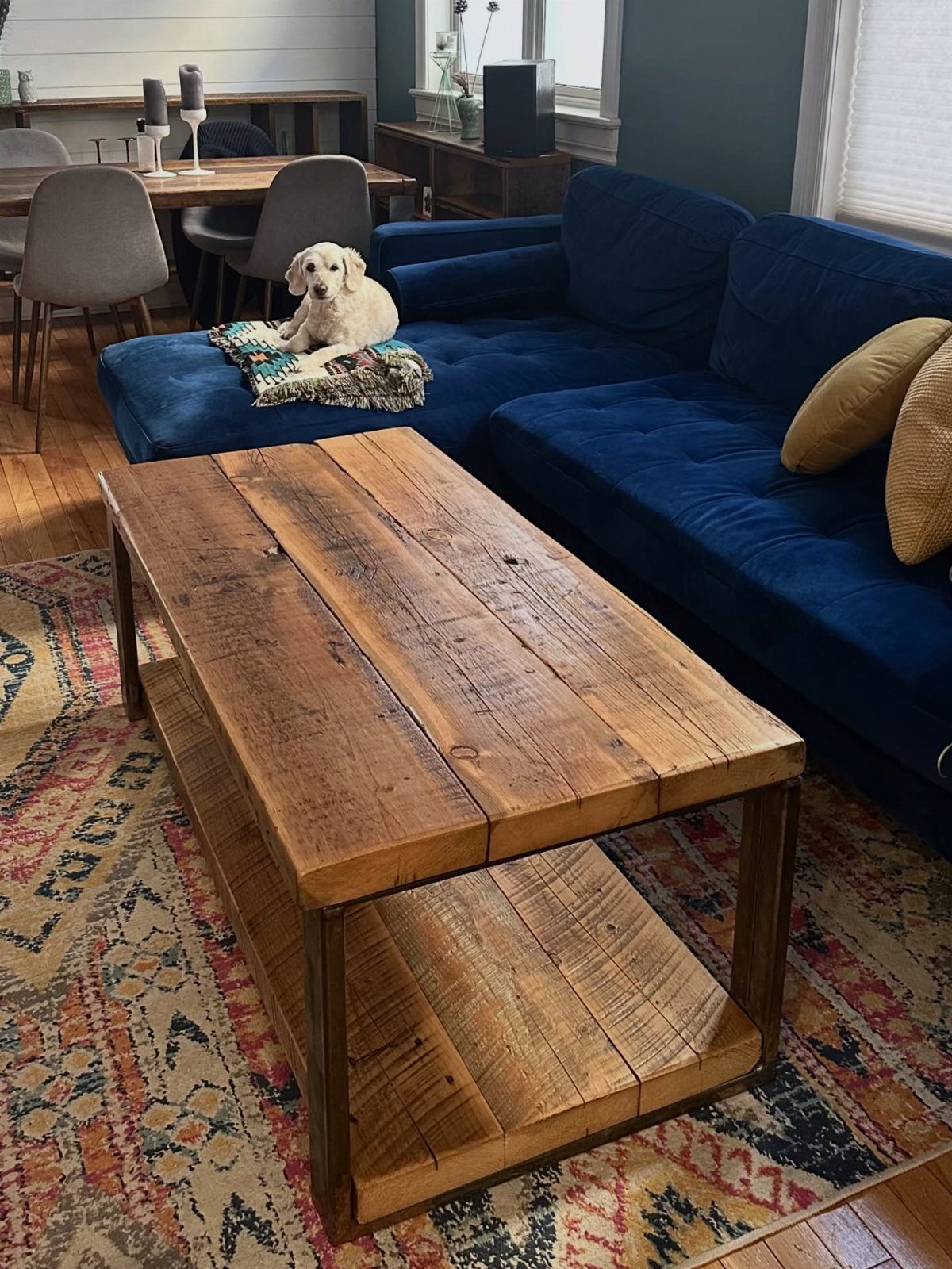 9 Woodworking Coffee Table Ideas for Every Skill Level 4 Rustic wood and steel coffee table in a living room with a blue sofa.