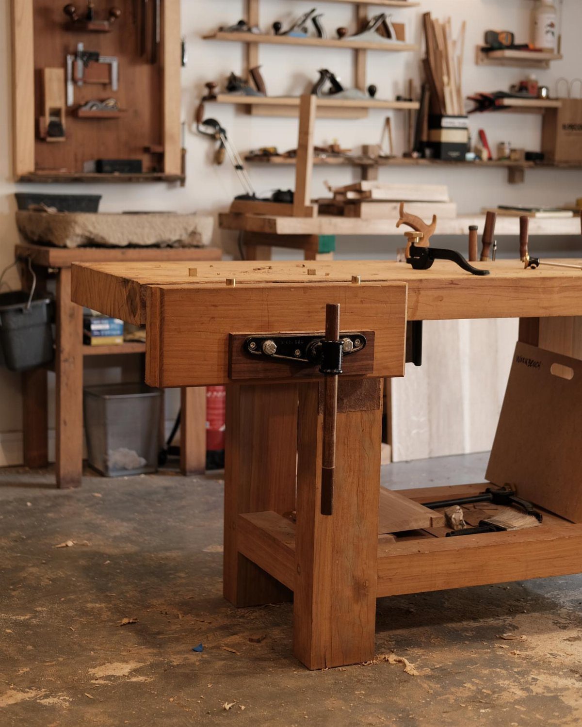 5 Woodworking End Vise Ideas for Your Workbench 4 Wooden woodworking workbench with a metal end vise installed on the side.