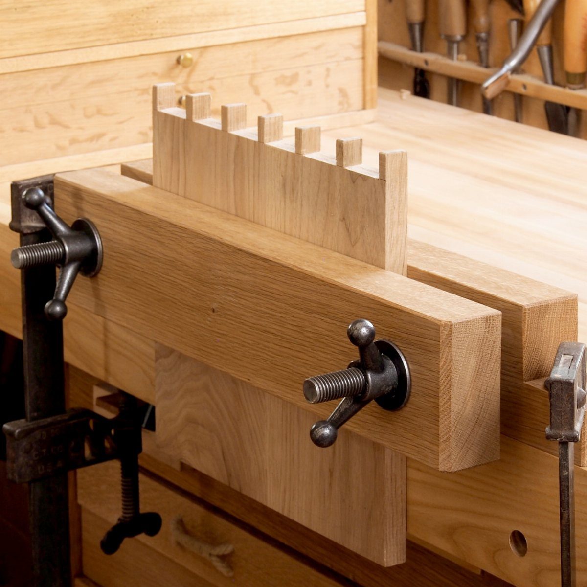5 Woodworking End Vise Ideas for Your Workbench 1 Twin-screw woodworking end vise clamping a notched piece of wood on a workbench.