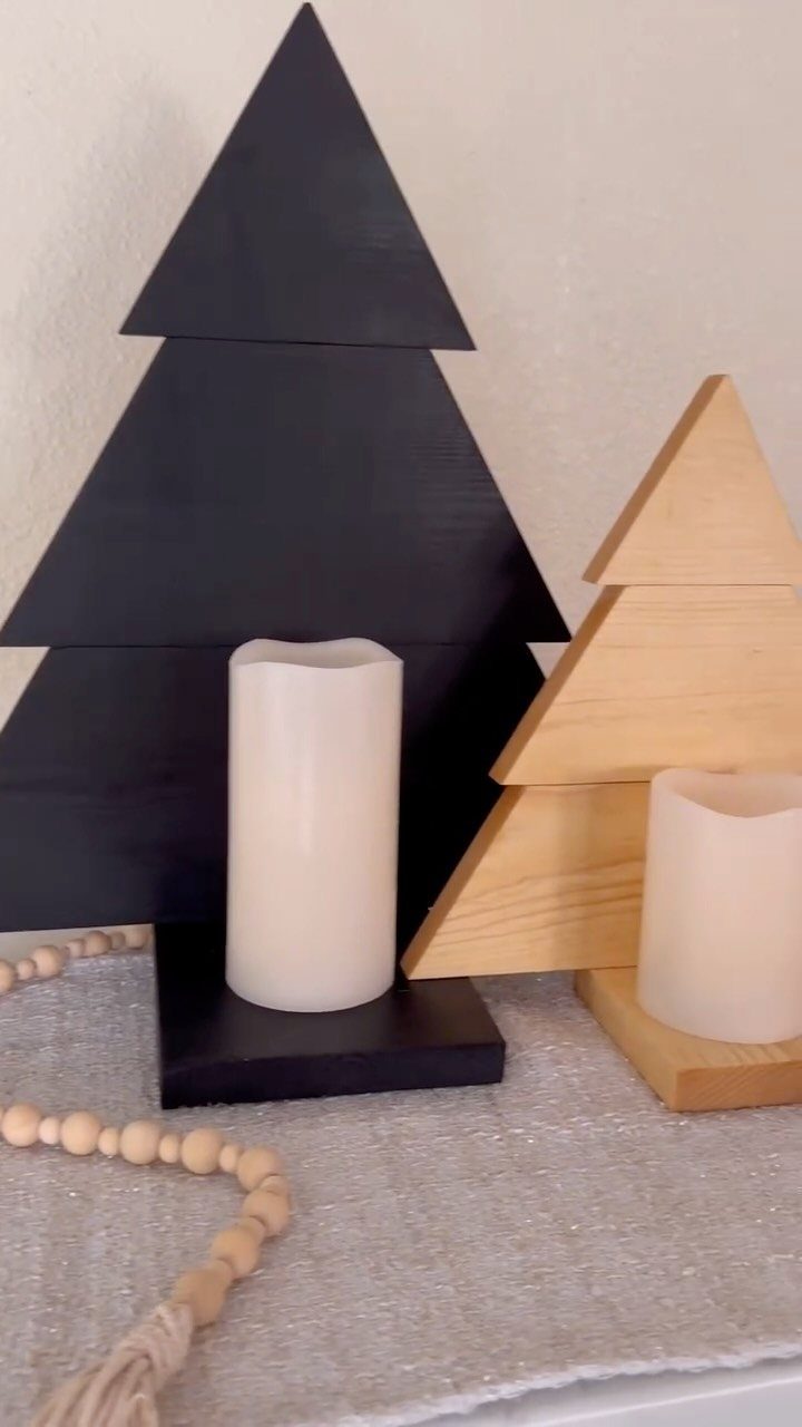 14 Woodworking Ideas to Make Money From Your Shop 5 Wooden tree-shaped candle holders in black and natural wood with white pillar candles.
