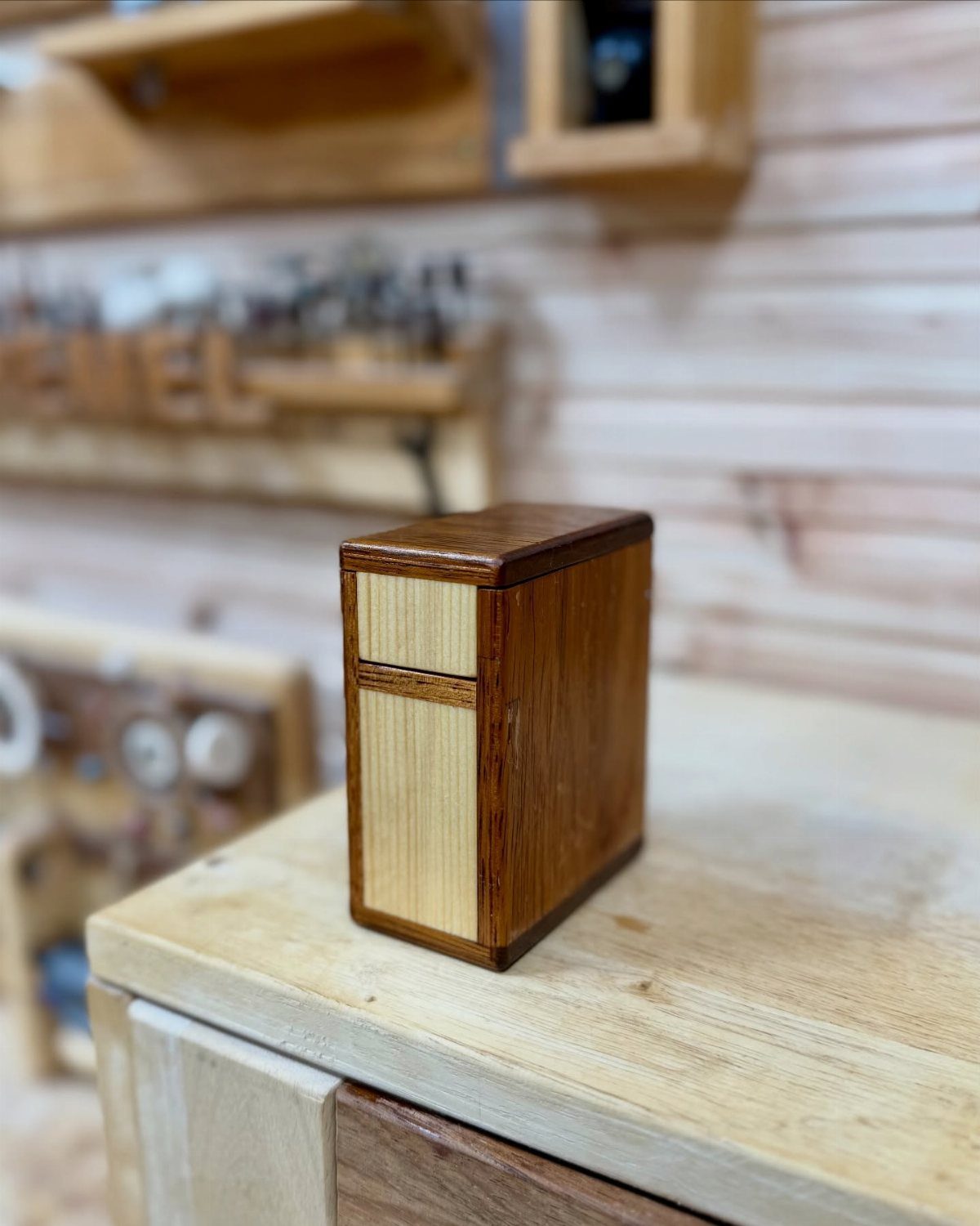 14 Woodworking Ideas to Make Money From Your Shop 3 Small rectangular wooden box with contrasting light and dark wood on a workbench.