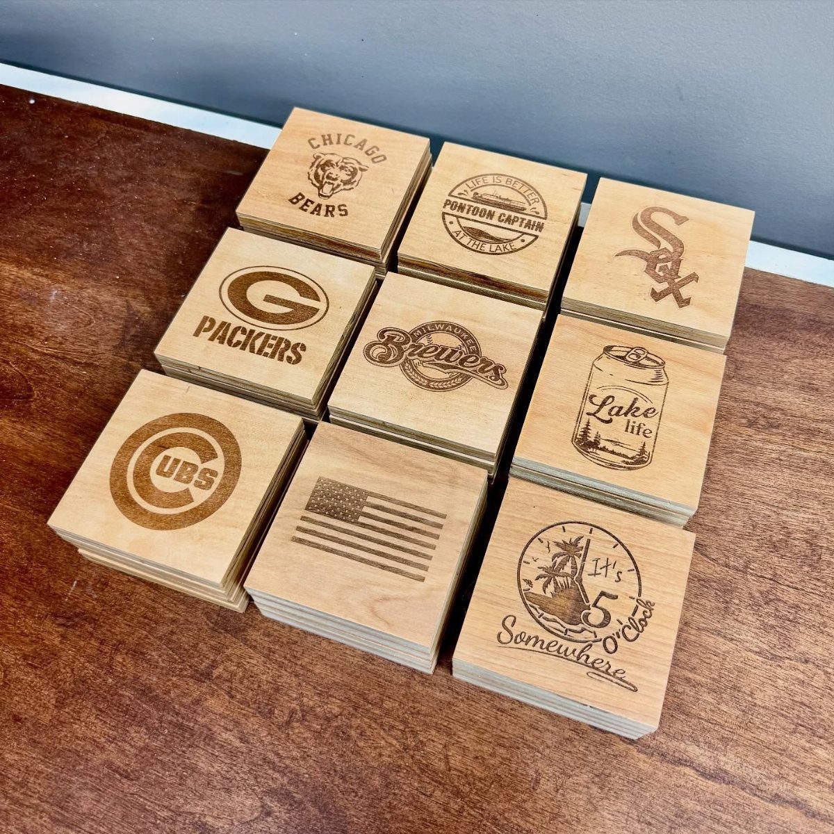 14 Woodworking Ideas to Make Money From Your Shop 9 Wooden coasters with engraved sports logos and phrases on a wooden table