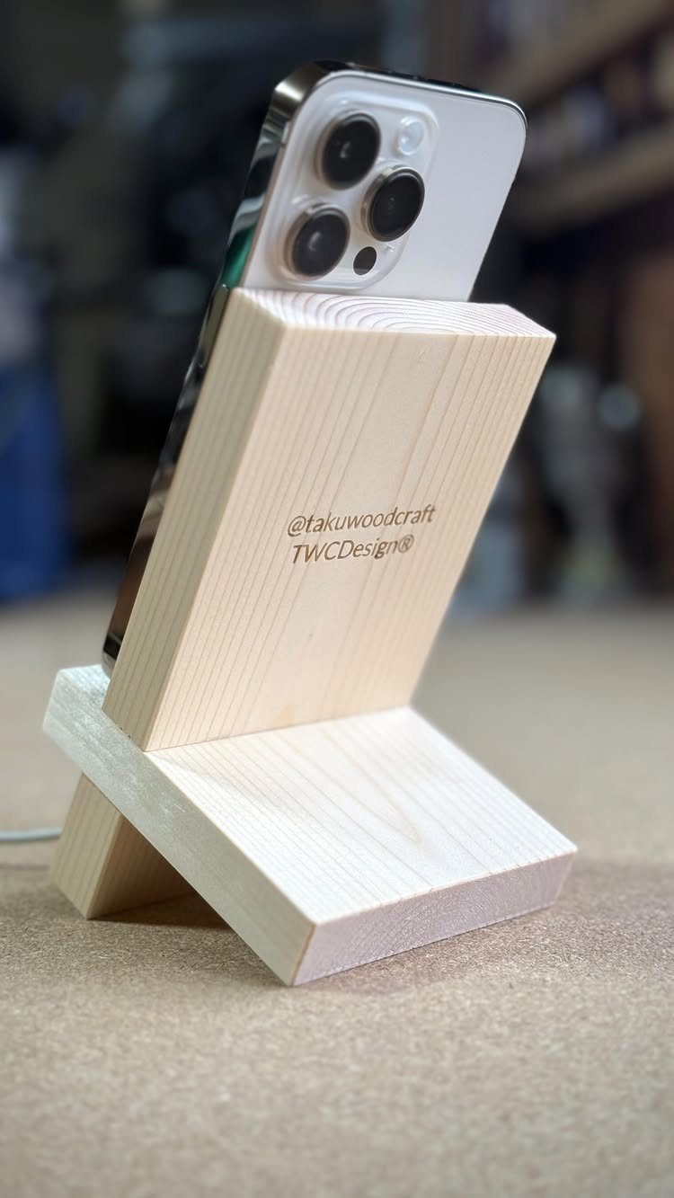 14 Woodworking Ideas to Make Money From Your Shop 13 Wooden phone stand holding a silver smartphone on a neutral surface.