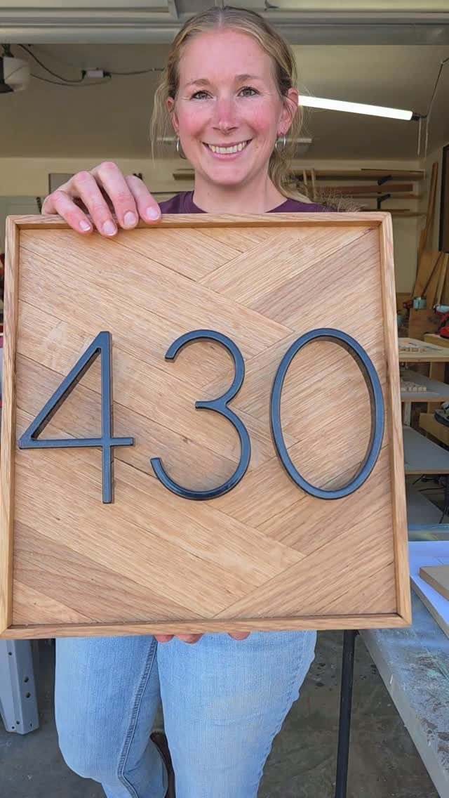14 Woodworking Ideas to Make Money From Your Shop 1 Woman holding a square wooden address sign with black numbers 430 on herringbone wood.